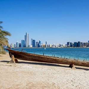 Traditional boat in the Heritage Village with city skyline in the background, Abu Dhabi