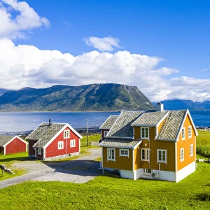 Traditional houses next to Hogsteinen Lighthouse by the sea, Godoya Island, Alesund