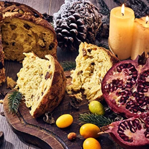 Traditional Italian Christmas cake with candles, pomegranate and winter fruits, panettone