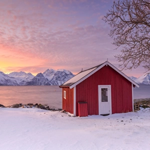 Traditional Norwegian house during a sunset on the fjord. Nordmannvik, Kafjord, Lyngen Alps