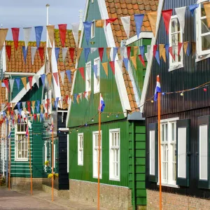 Traditional wooden houses decorated with flags of Dutch national colors for Koningsdag