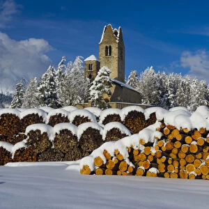 Trunks and old church in Celerina with pristine snow. Engadine, Switzerland, Europe