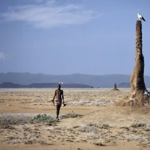 A Turkana man strides purposefully across the treeless