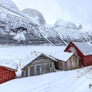 Typical wooden huts in the snowy landscape of Lyngseidet Lyngen Alps Tromsa¸ Lapland Norway Europe
