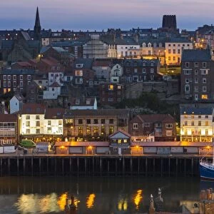 United Kingdom, England, North Yorkshire, Whitby. A view of the harbour at dusk