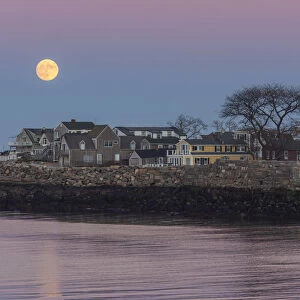 USA, Massachusetts, Cape Ann, Rockport, moonrise over buildings on Bearskin Neck, dusk