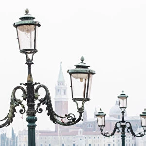 Venice, Veneto, Italy. Typical street lamps and San Giorgio Maggiore in a misty morning