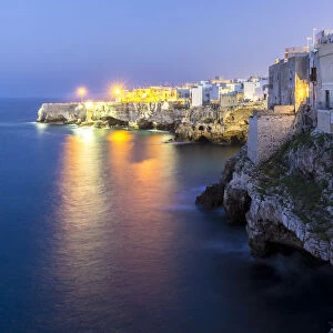 View of the overhanging houses and caves of Polignano a Mare at night. Bari district