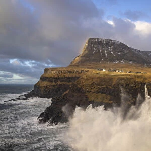 The village of Gasadalur and its waterfal hit by a storm. Island of Vagar. Faroe Islands