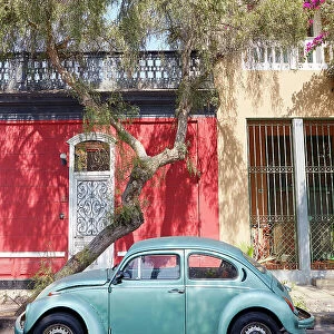 A vintage Volkswagen beetle car in front of a colonial house in Barranco, Lima, Peru. Lima is also known as the "City of the Kings"and was declared UNESCO World Heritage site in 1988