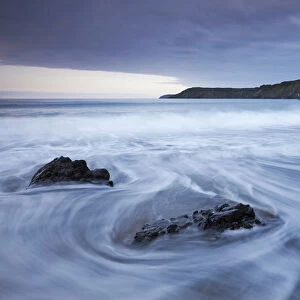 Waves rush onto the beach at Kennack Sands, Lizard Peninsula, Cornwall, England. Spring