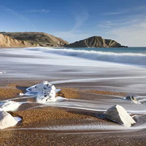 Waves wash clean the beautiful beach at Worbarrow Bay on the Jurassic Coast, Dorset