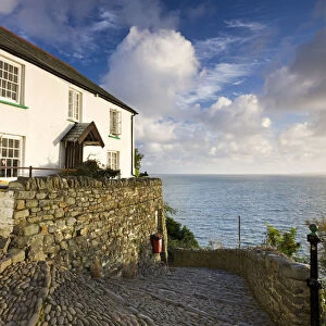 Whitewashed cottage and cobbled lane in the picturesque village of Clovelly, Devon