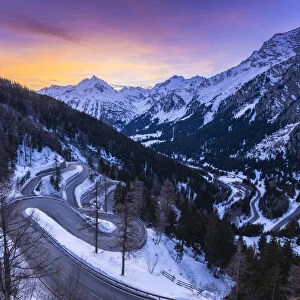 The winding curves of Maloja Pass road in winter at sunset, Bregaglia Valley, canton of Graubünden, Engadin, Switzerland