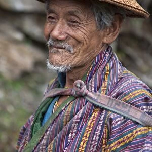 A wizened old farmer near Mongar wears the traditional knee-length national robe called gho