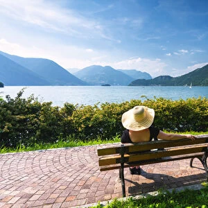 Woman on the bench in Iseo lake, Lombardy district, Brescia province, Italy. (MR)