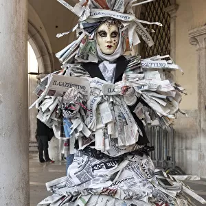 A woman covered in newspaper walks through St. Mark