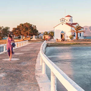 A woman crossing the bridge that link Elafonissos island with the orthodox church of St
