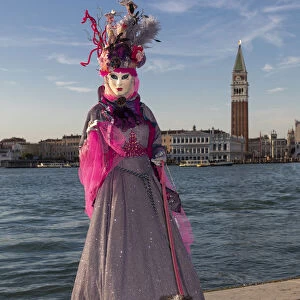 A woman and her dog pose in costume during the Venice Carnival, San Giorgio Maggiore