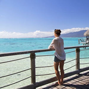 Woman on jetty of overwater bungalows of Sofitel Hotel, Moorea, Society Islands, French