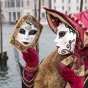 Woman in red costume and her reflecion in mirror, grand Canal, Venice, Veneto, Italy