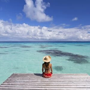 Woman sitting on jetty, Fakarava, Tuamotu Islands, French Polynesia (MR)