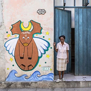 A woman standing in the doorway of her house in La Habana Vieja (Old Town), Havana, Cuba