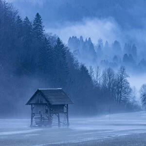 Wooden barns in Mist near Lake Bohinj, Slovenia