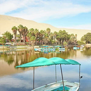 A wooden boat on the shore of the Huacachina Oasis, Ica, Peru