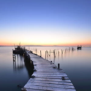 Wooden pillars piers, a palafite fishing harbour of Carrasqueira at dusk. Alentejo