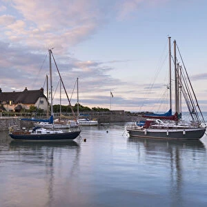 Yachts in Porlock Weir harbour at sunset, Exmoor, Somerset, England. Summer (July)