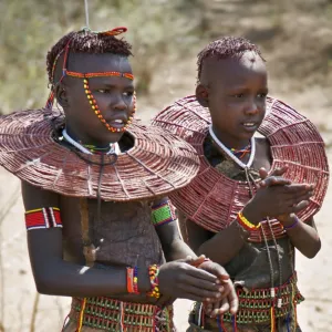 Two young Pokot girls wearing traditional ornaments that denote their unmarried status