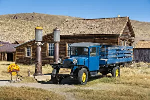 Mono County Collection: Abandoned blue old pickup truck and wooden deserted buildings in Bodie ghost town