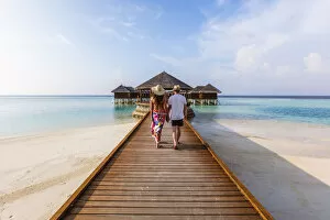 Adult couple walking on jetty, Maldives (MR)