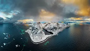 Lofoten Prints: Aerial panoramic of snowcapped mountains and Nedre Heimdalsvatnet lake under clouds at sunset