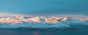 Climate Collection: Aerial panoramic view of Senja mountain peaks covered with snow at dawn from Sommaroy