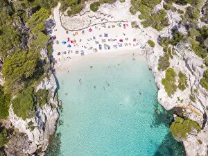 Aerial view of Cala Macarelleta beach crowded in summer, Menorca, Balearic Islands, Spain