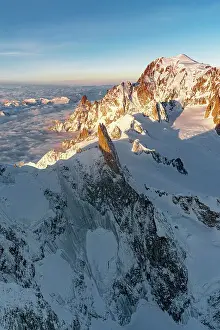 Pennine Alps Prints: Aerial view of Dent du Geant rock pinnacle in Mont Blanc Massif covered with snow at dawn