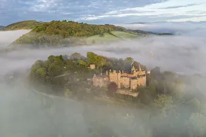 Aerial view of Dunster Castle on a misty autumn morning, Exmoor National Park, Somerset, England. Autumn (October) 2022