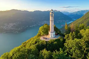Lake District Prints: Aerial view of the Faro Voltiano (Volta Lighthouse) of Brunate overlooking Como and Como Lake in summer at sunset
