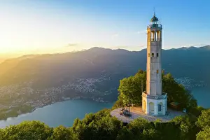 Como District Prints: Aerial view of the Faro Voltiano (Volta Lighthouse) of Brunate overlooking Como and Como Lake in summer at sunset