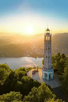 Lake District Prints: Aerial view of the Faro Voltiano (Volta Lighthouse) of Brunate overlooking Como and Como Lake in summer at sunset