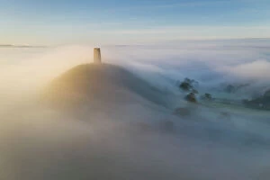 Images Dated 12th June 2023: Aerial view of Glastonbury Tor shrouded in morning mist, Glastonbury, Somerset, England