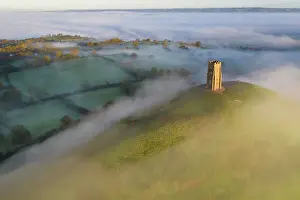 Glastonbury Prints: Aerial view of Glastonbury Tor surrounded by morning mist