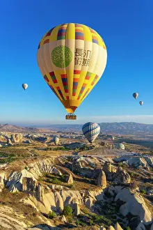 Kapadokya Prints: Aerial view of hot air balloon over rock formations at sunrise