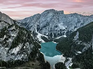 Bolzano Prints: Aerial view of the idyllic lake Braies / Pragser Wildsee under a pink sky at sunset in autumn