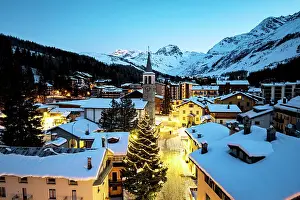 Rooftop Prints: Aerial view of the illuminated snowy village of Madesimo at dawn at Christmas