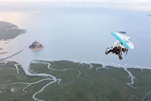 aerial view of Mont Saint Michel and Ultra light aircraft at high tide, Manche, France