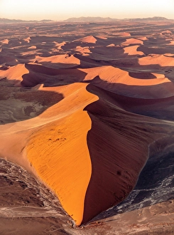 Aerial view of orange sand dunes from helicopter, Sossusvlei, Namib-Naukluft National Park, Namib Desert, Namibia