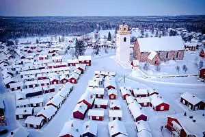 Building Exterior Prints: Aerial view of red cabins and church covered with snow at dusk with Lapland forest on background